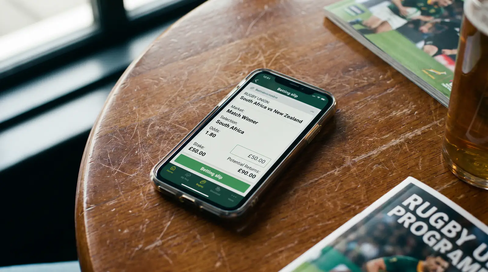 Close-up of a rugby betting slip on a mobile screen showing selection market and stake
