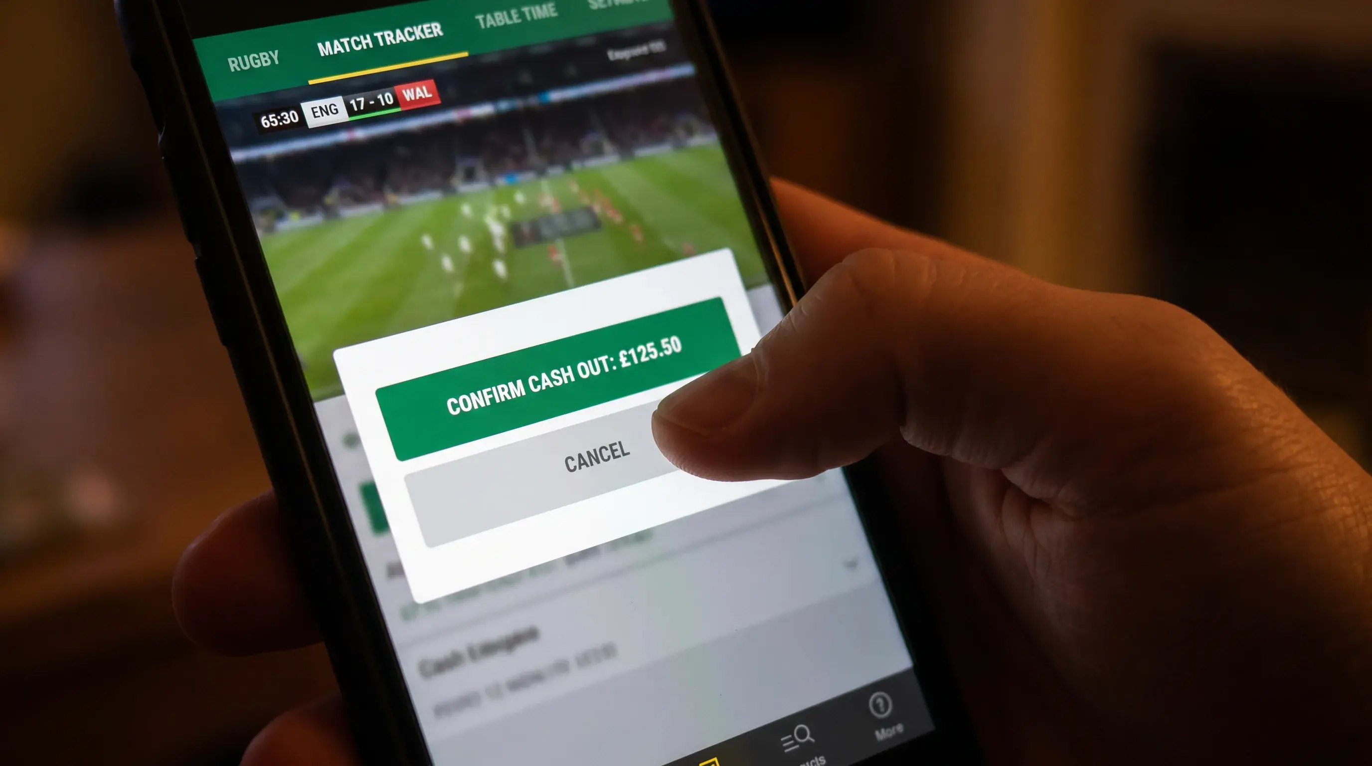 Smartphone screen displaying a cash-out confirmation prompt during a live rugby match