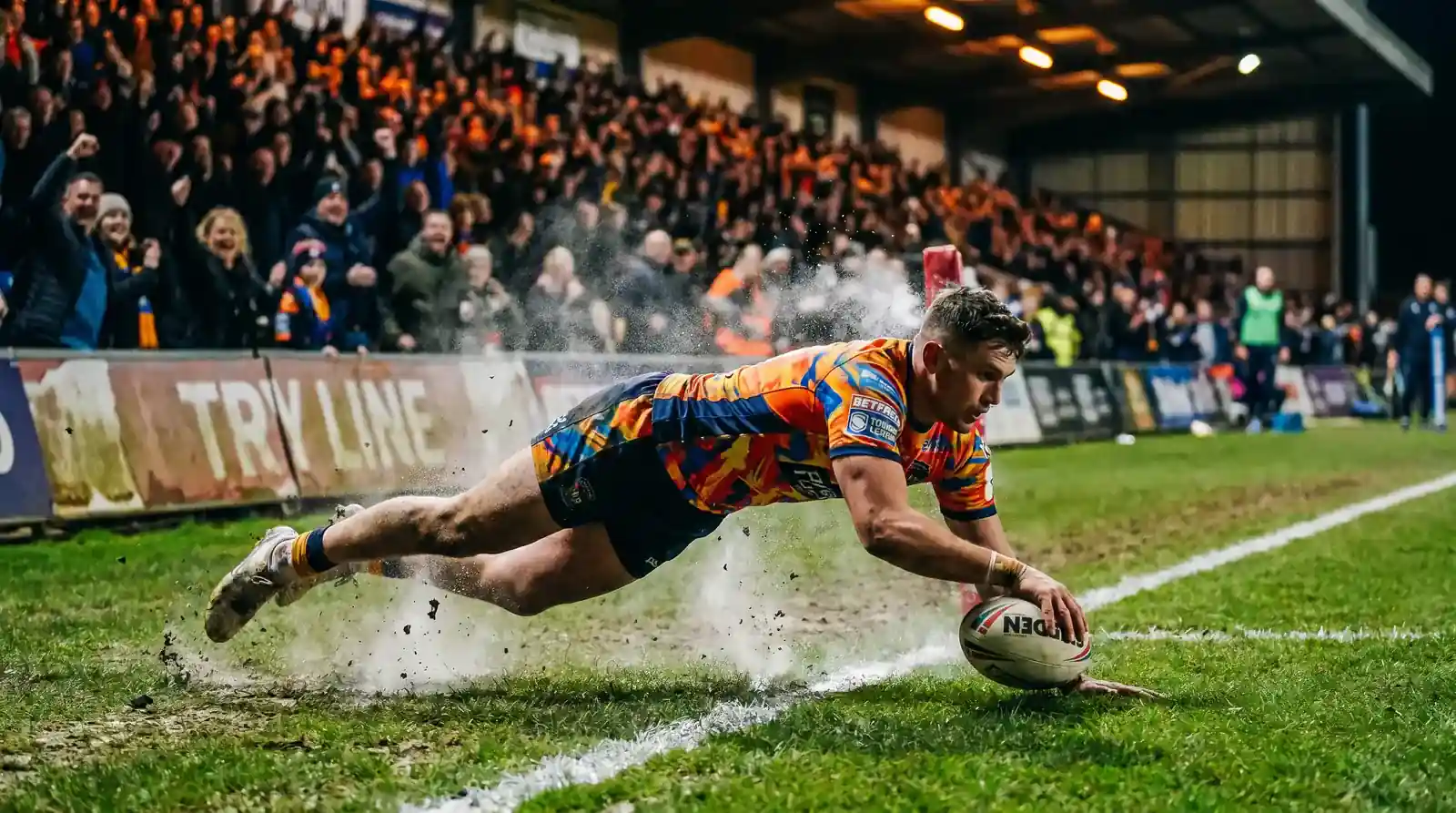 Rugby league player diving across the try line to score at a Super League match